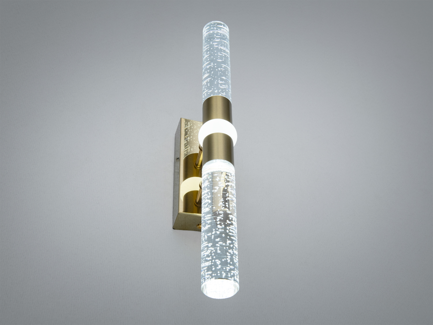 Сучасний настінний світильник з двома скляними циліндрами, наповненими бульбашками. Металевий монтаж для вертикальної установки.