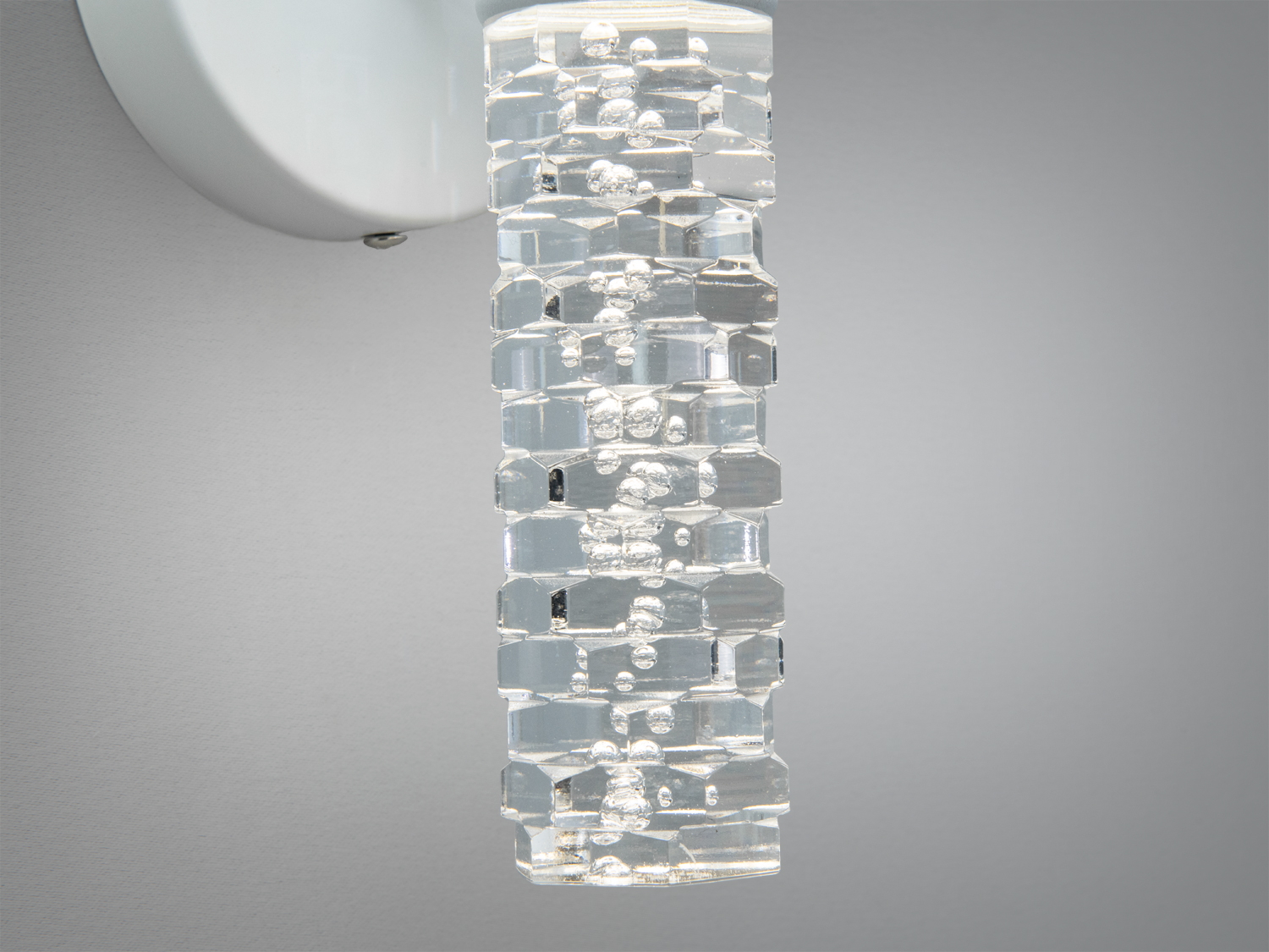 Детальний вигляд прозорого акрилового плафона настінного світильника, що імітує кришталь. Відображає світло, створюючи ефект блиску.