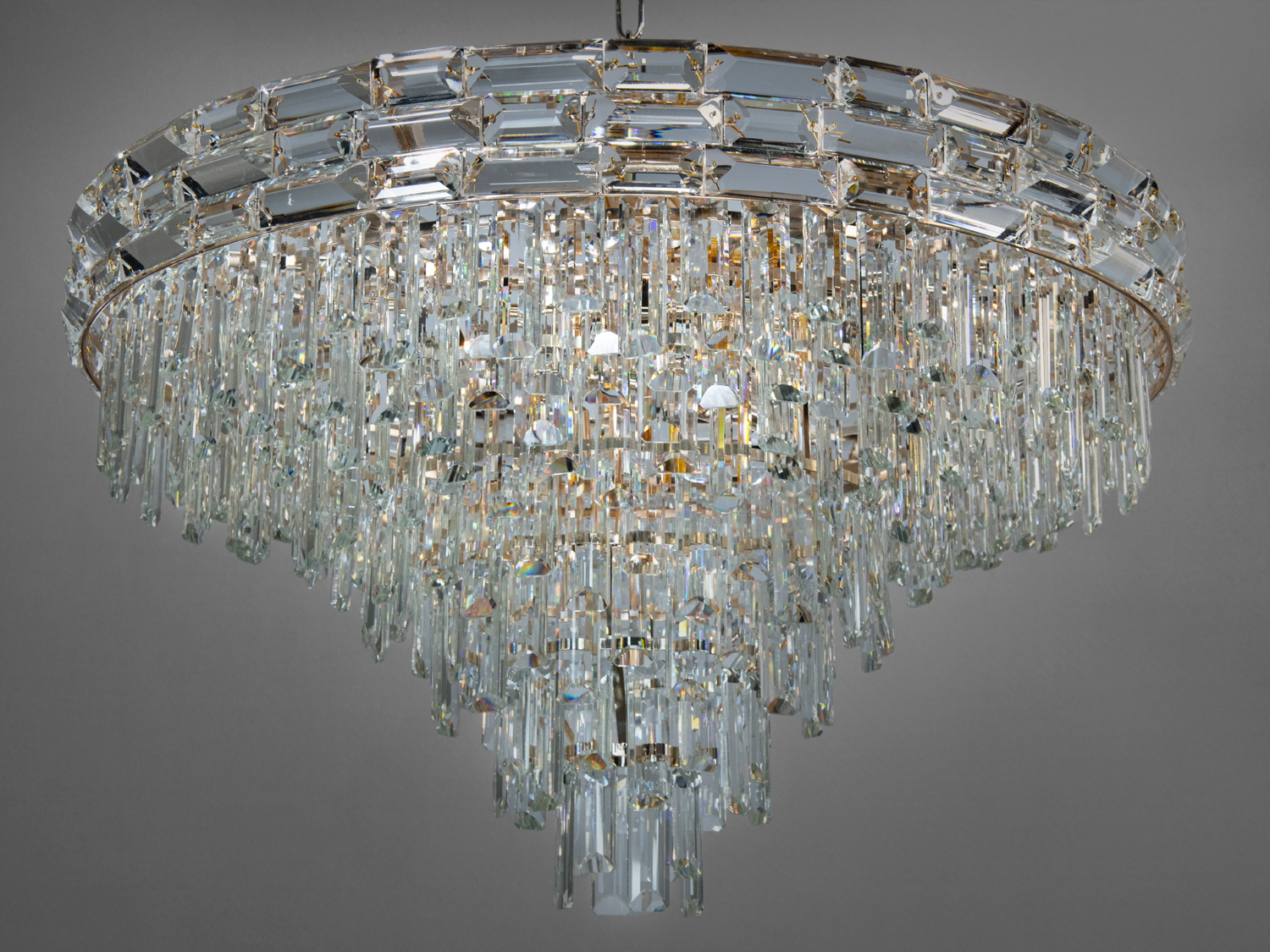 Елегантна люстра з багатоярусними кришталевими підвісками, що додають розкішності. Підвісний монтаж для просторих приміщень.