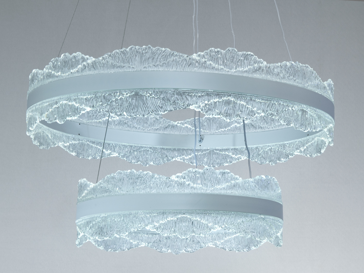 Підвісна люстра з холодним світлом, два кільця з прозорого матеріалу створюють ефект легкості.