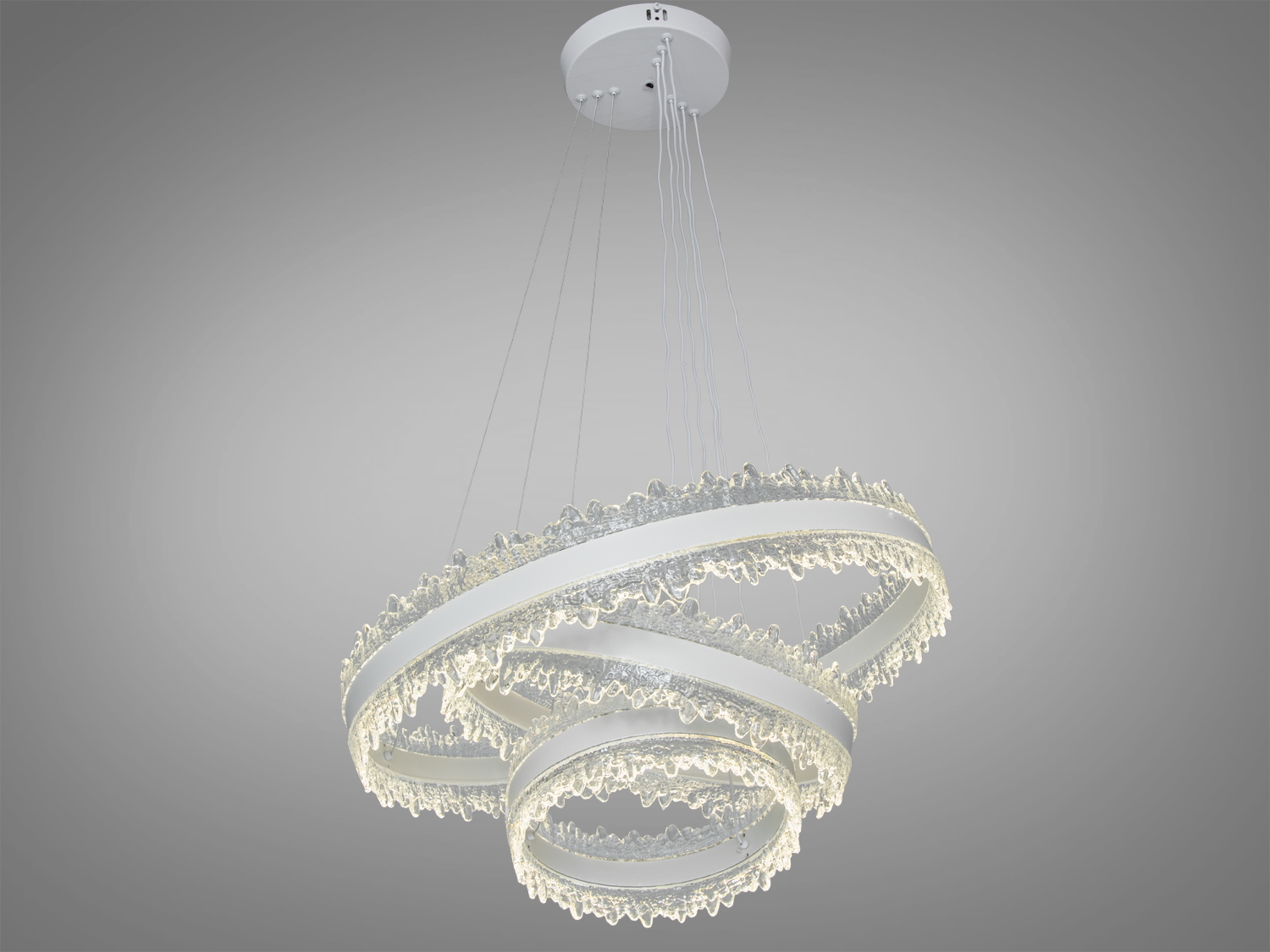 Люстра з трьома кільцями, підвішена на тонких дротах до стелі, створює сучасний стиль в інтер′єрі.