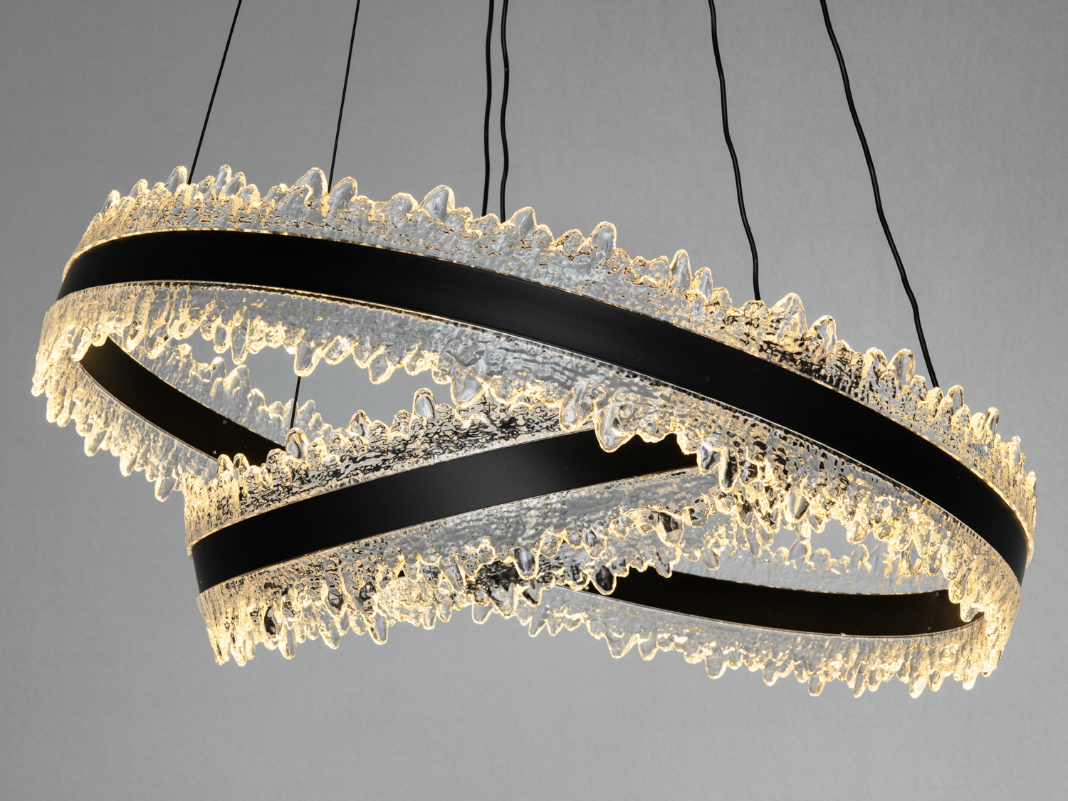 Кришталевий світильник з теплим білим світлом, що надає затишку. Підвісні кільця мають текстуровану поверхню.