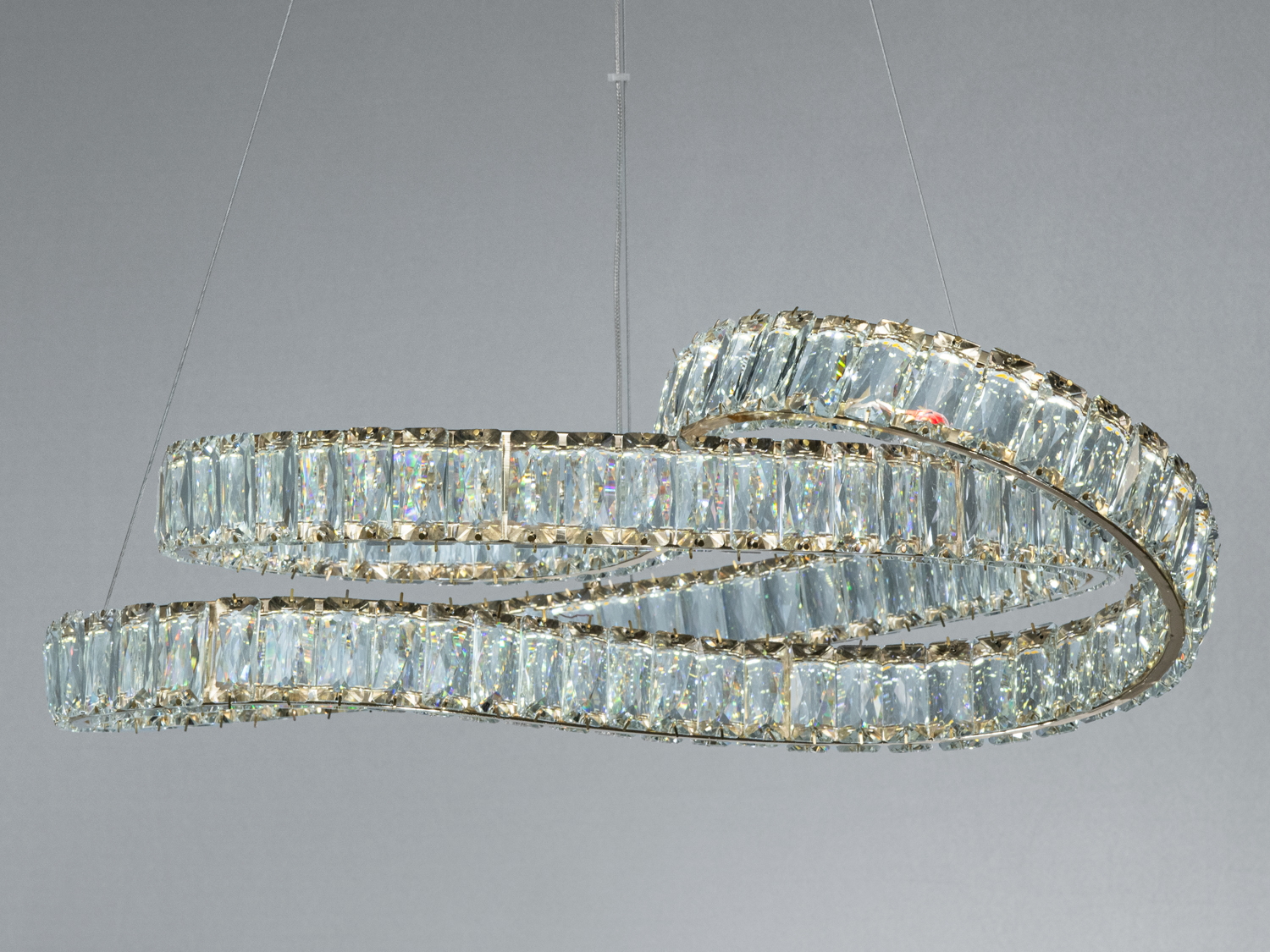 Спіральна люстра з кришталевими вставками, підвісна конструкція, створює ефектний світловий акцент у просторі.