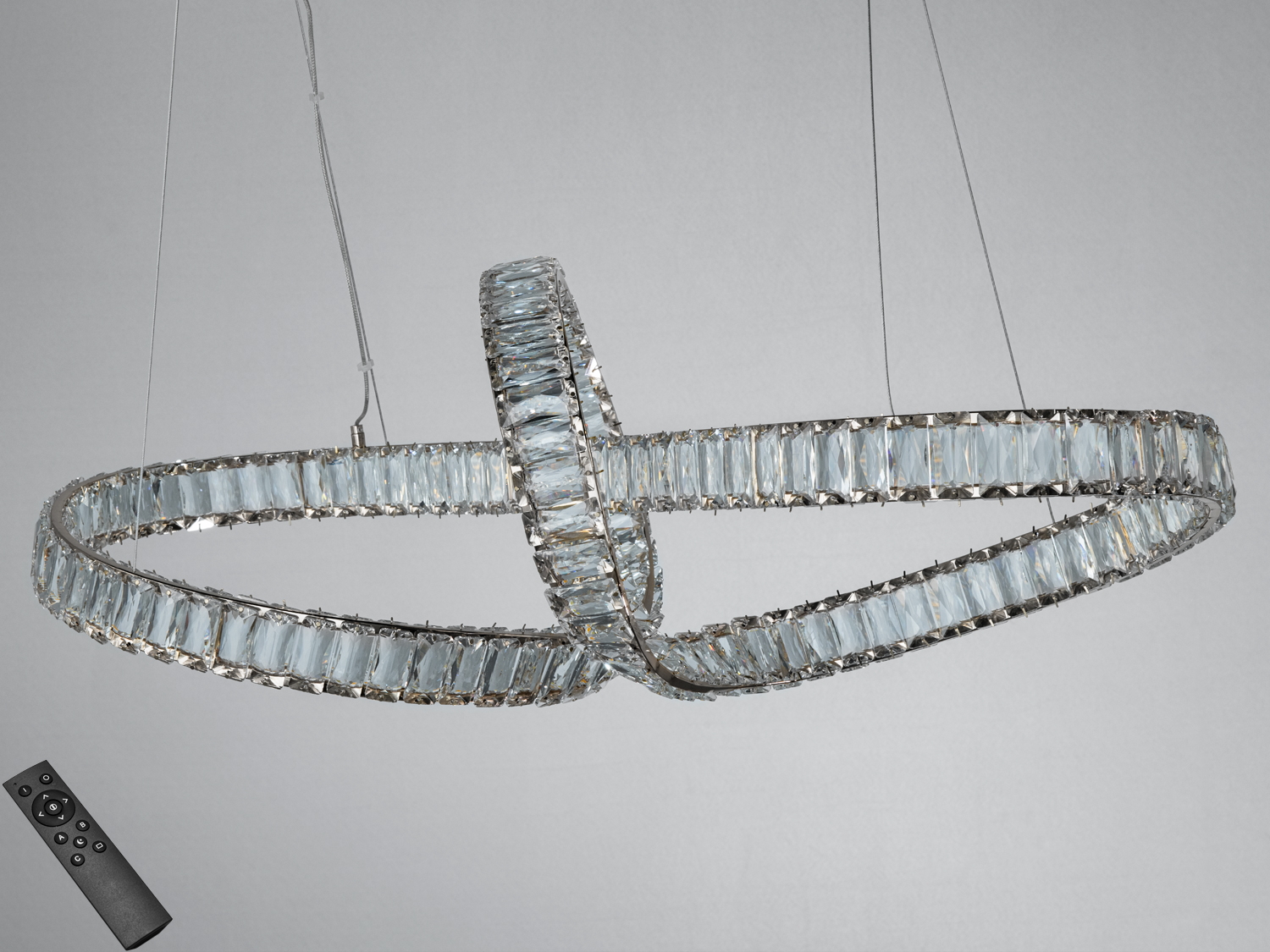 Підвісний світильник з кришталевими елементами, що формують переплетені кільця. В комплекті пульт дистанційного керування.