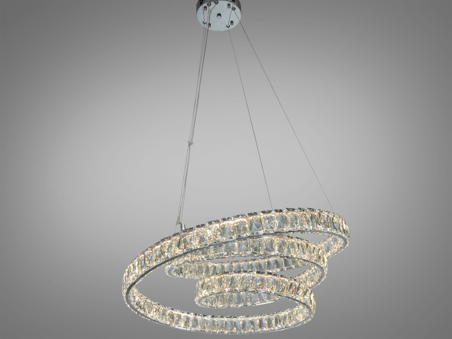 Круглий підвісний світильник з трьома кристалічними кільцями. Підходить для сучасного інтер′єру, кріпиться до стелі на тросах.