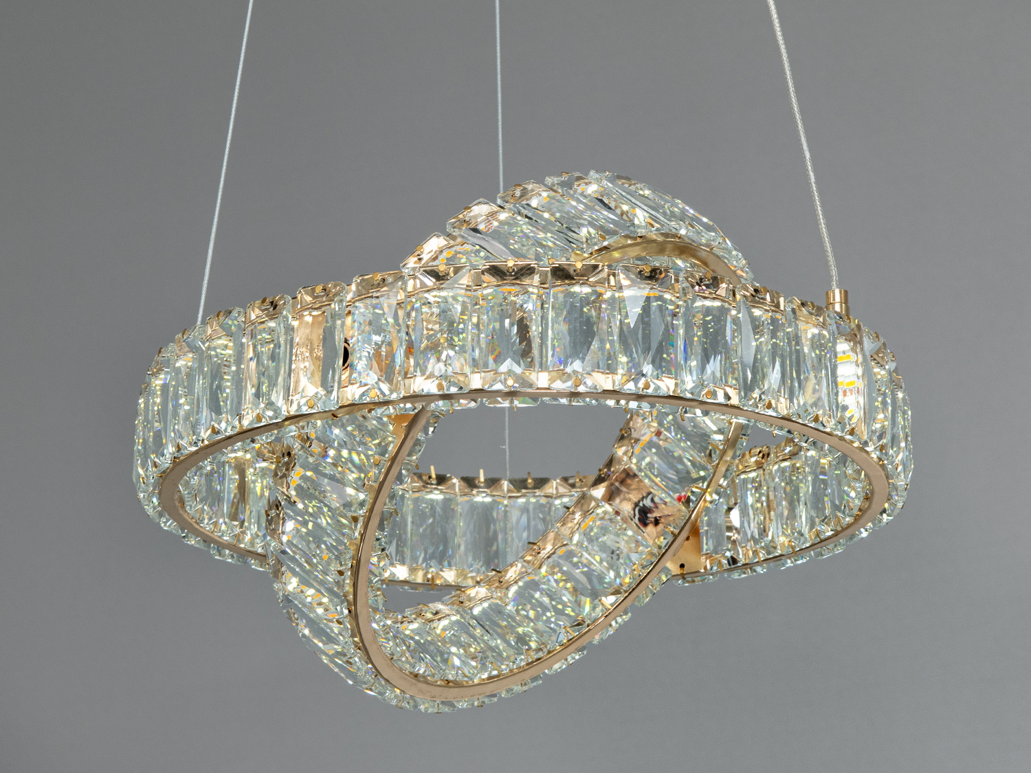 Кришталева люстра з переплетеними кільцями, підвісна. Призначена для вітальні, забезпечує яскраве освітлення.