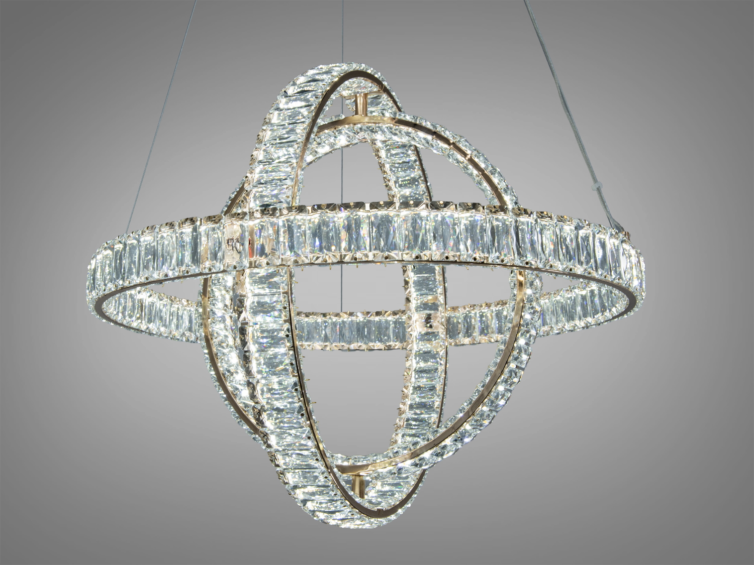 Люстра з кристалами, що формують кільця, підвішена на тросах. Відмінно підходить для вітальні або їдальні.
