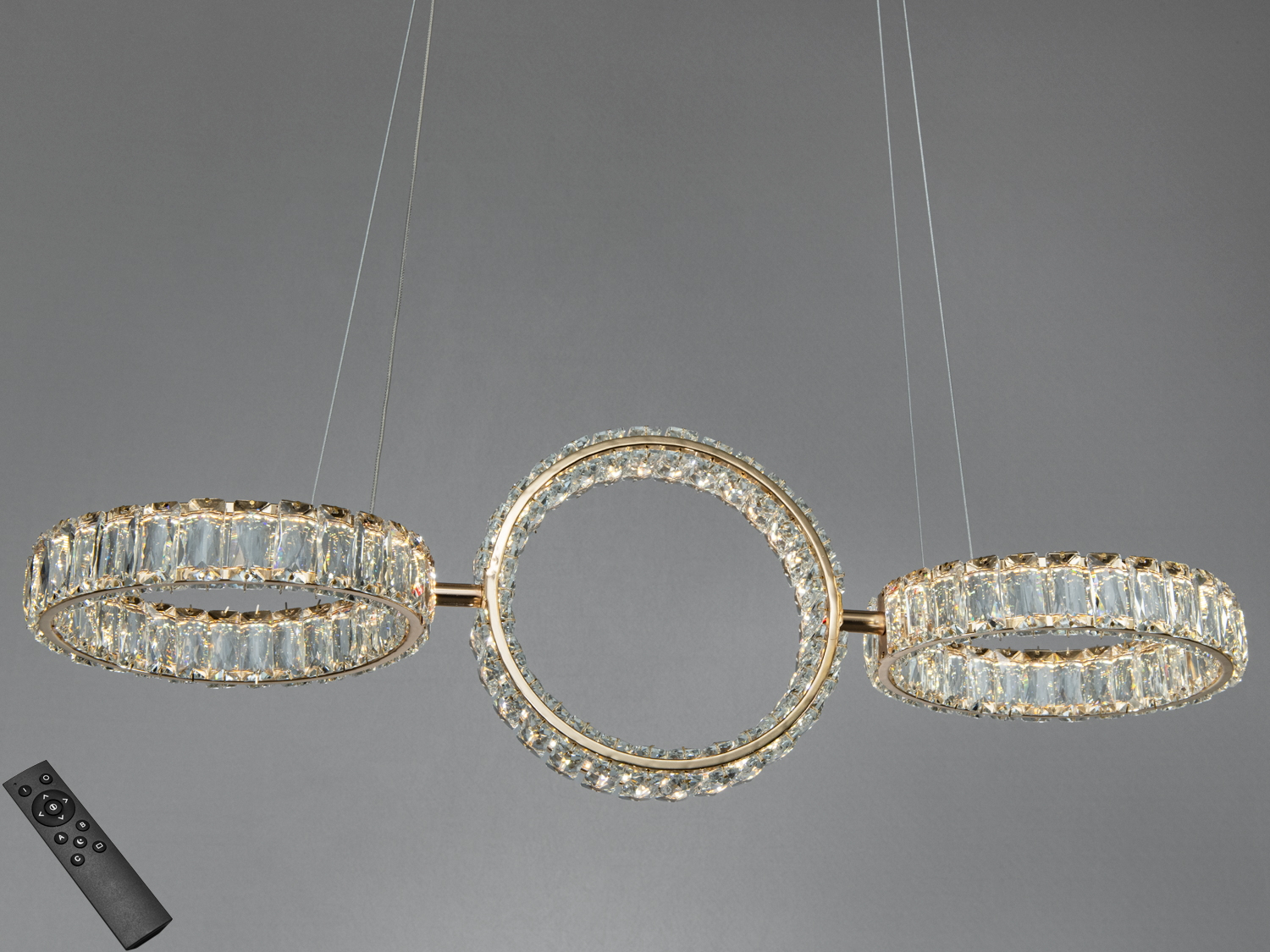 Підвісна люстра з трьома круглими кільцями, прикрашеними кристалами, з дистанційним керуванням для регулювання освітлення.
