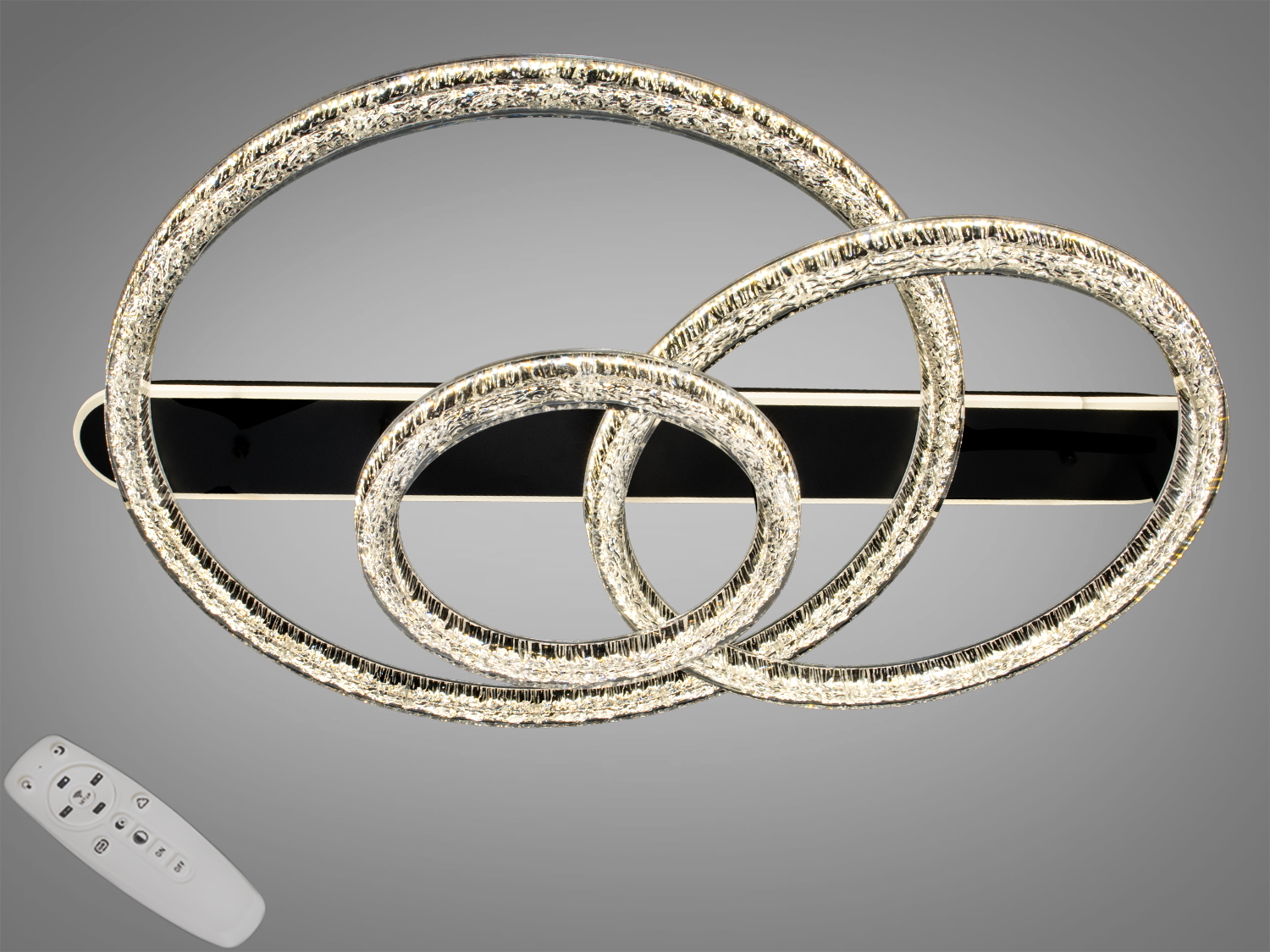 Настінний світильник з трьома переплетеними кільцями, оснащений пультом дистанційного керування. Підходить для сучасного інтер′єру.