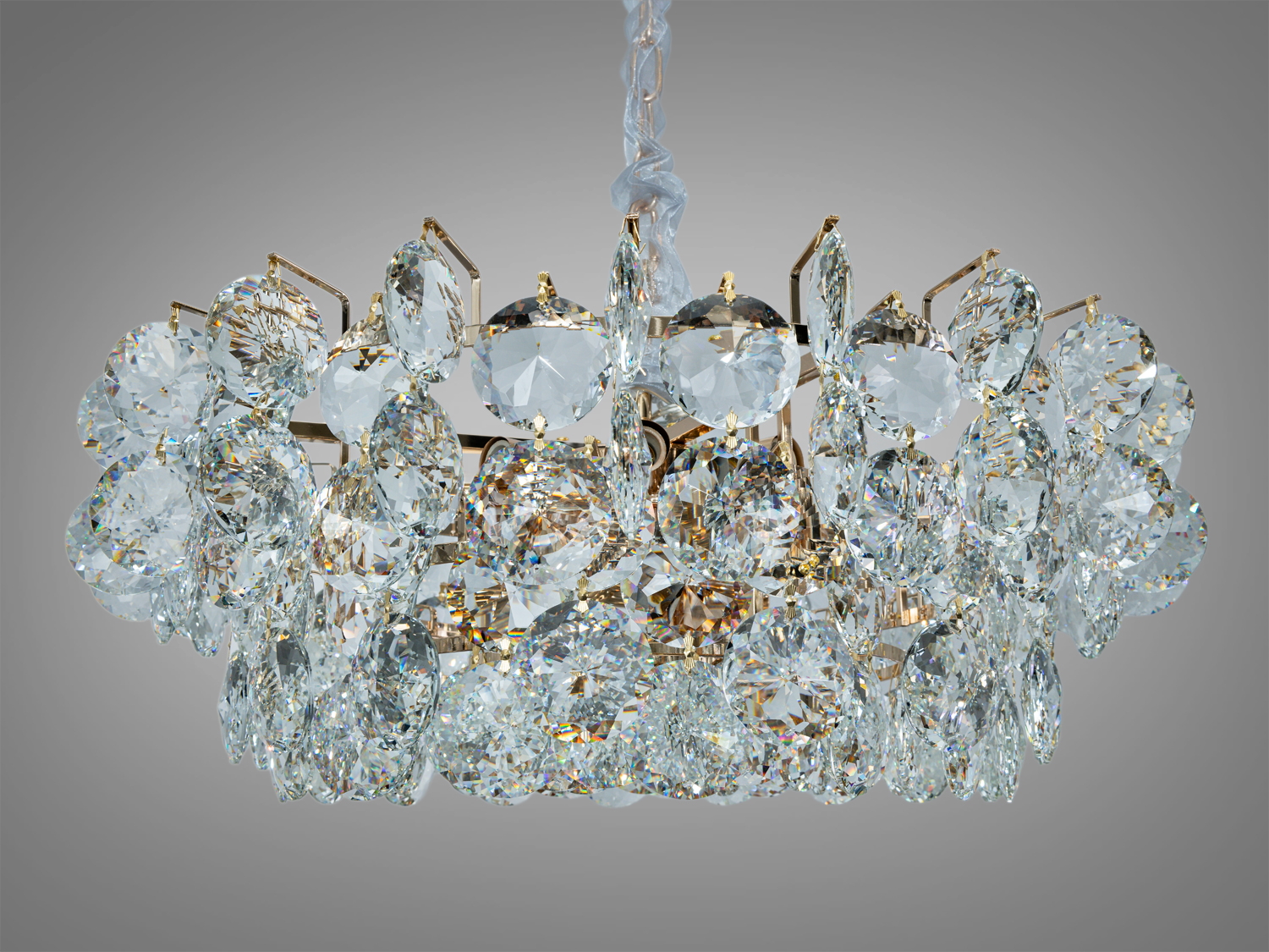 Кругла кришталева люстра з підвісами, що відбивають світло, підходить для вітальні.