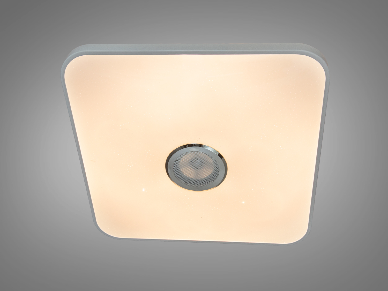 Квадратна стельова лампа з теплим жовтим світлом, має металевий елемент у центрі. Ідеальна для затишних житлових приміщень.