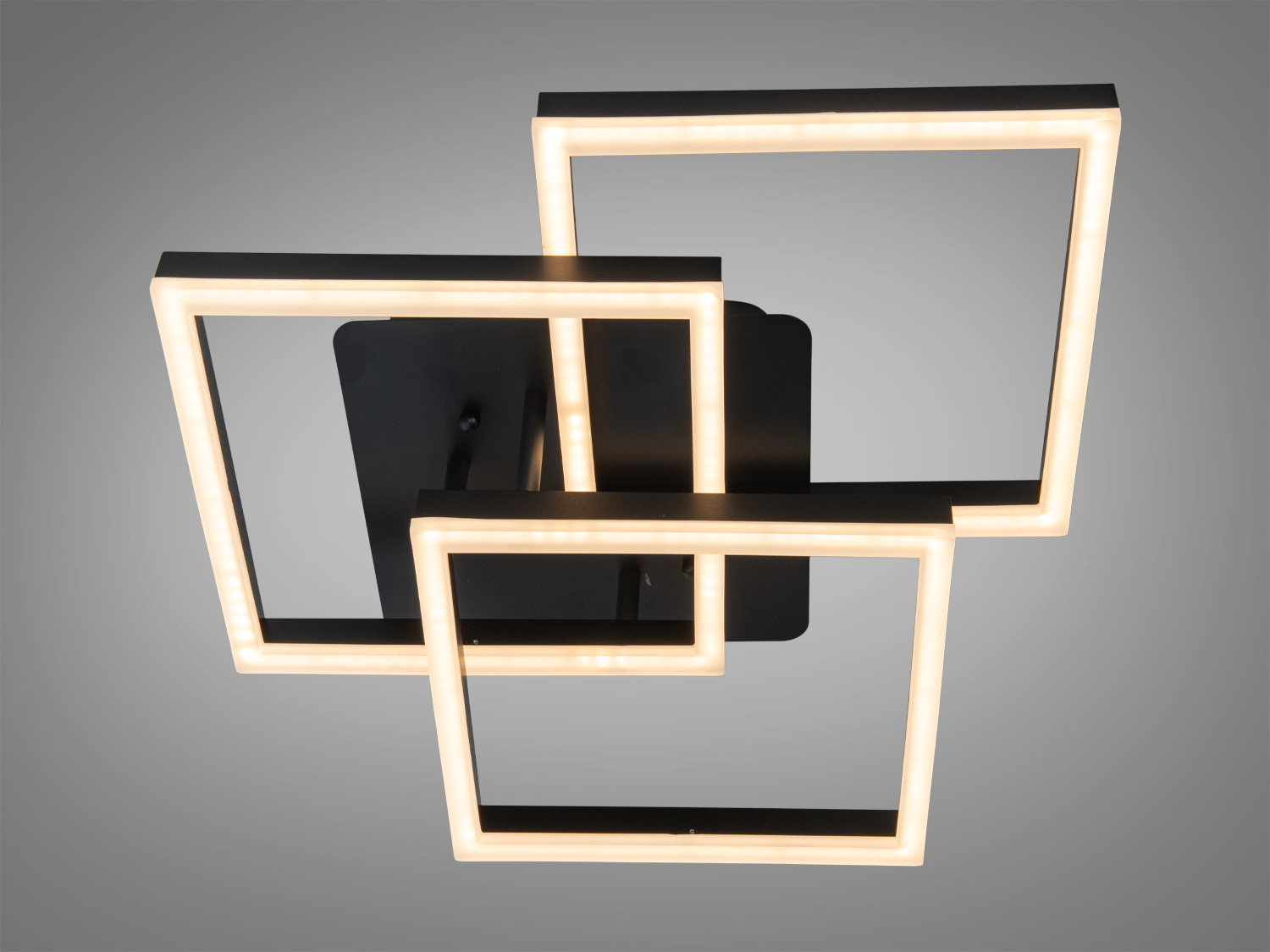 Настінний світильник з трьома квадратними рамками, що випромінюють тепле світло, ідеальний для затишних приміщень.