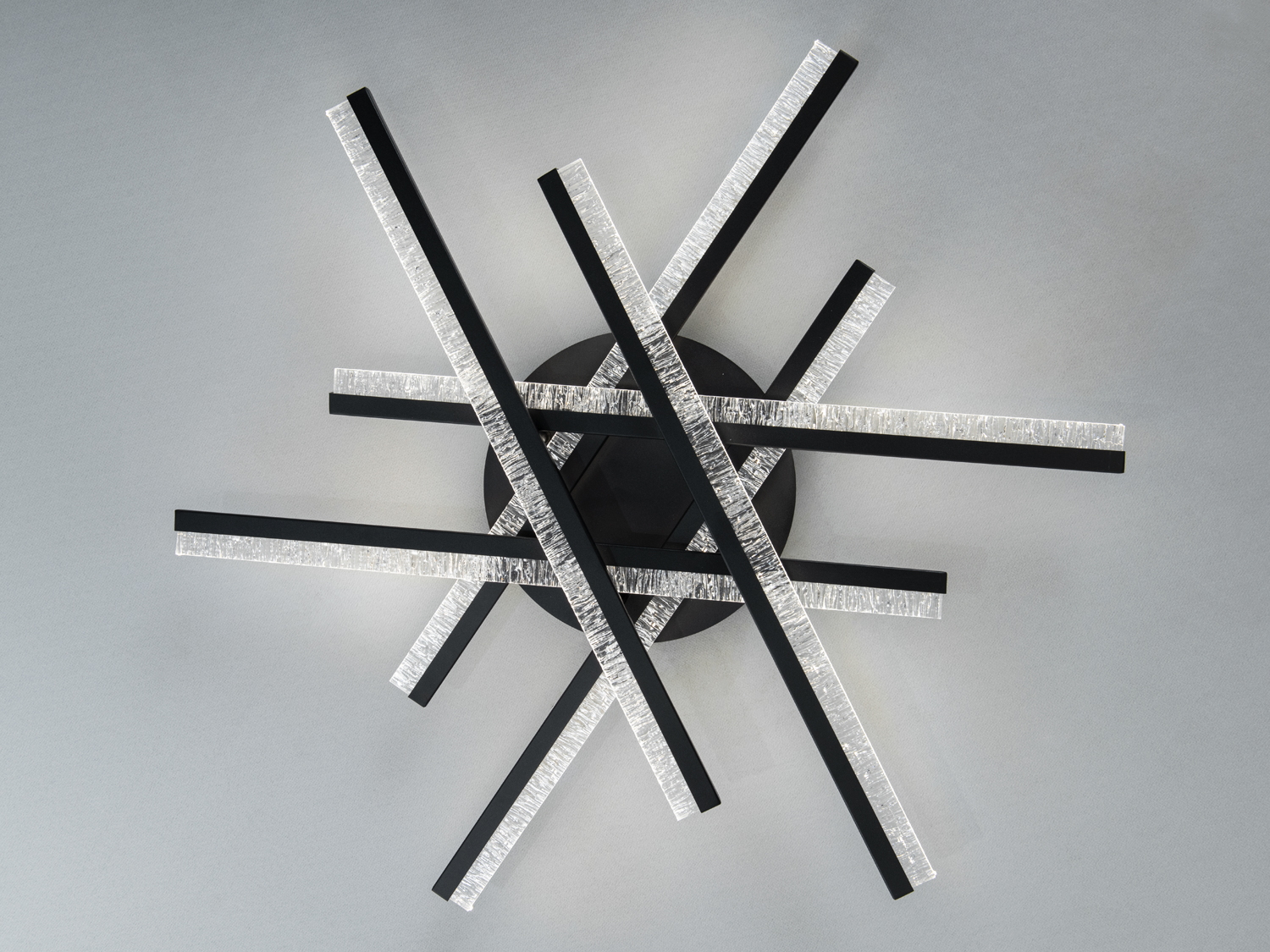 Стельовий світильник з чорними перехресними смугами та прозорими краями. Використовується для освітлення сучасних приміщень.