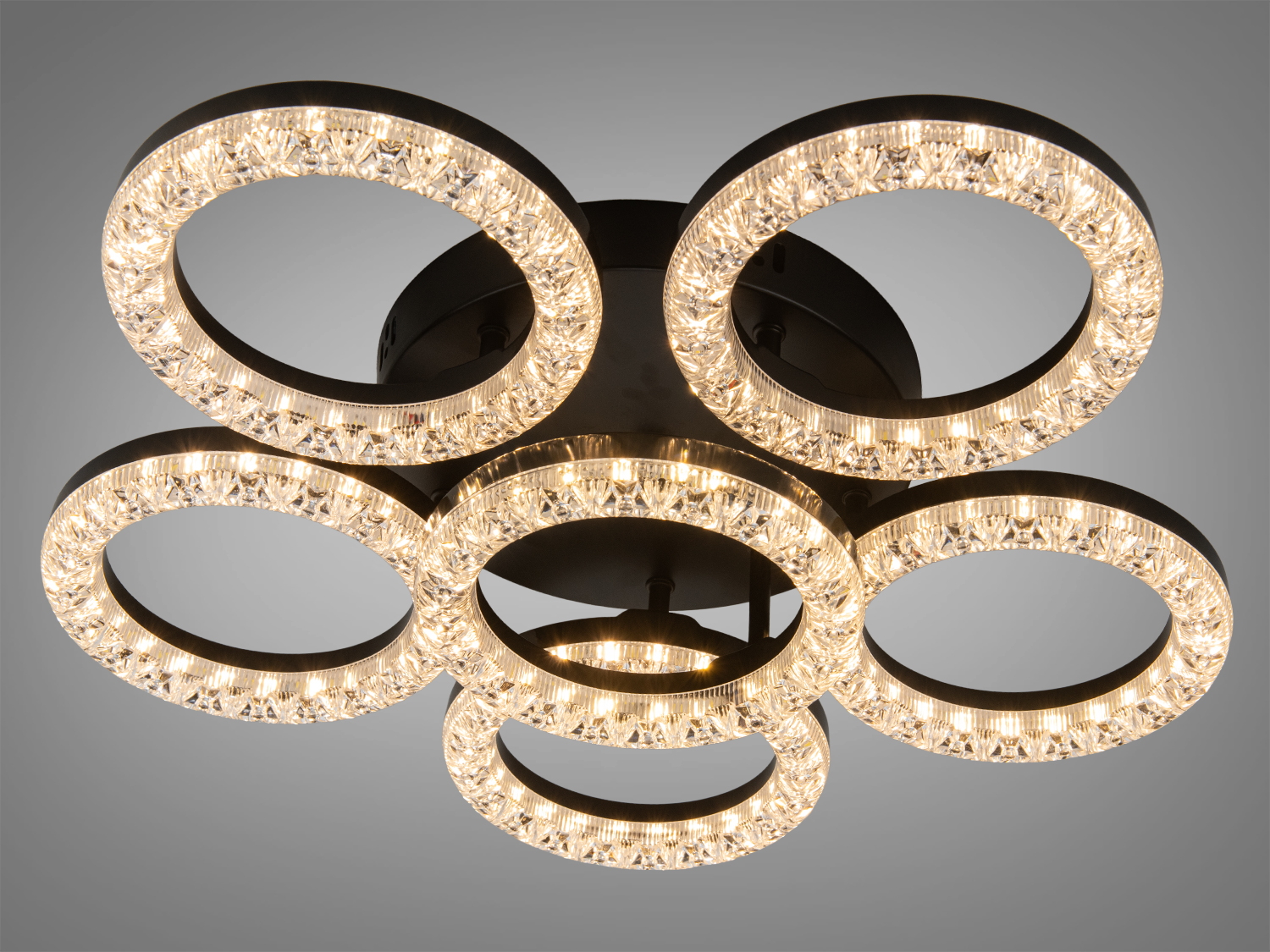 Стельова люстра з шістьма світлодіодними кільцями, що випромінюють тепле світло, з кришталевими вставками.