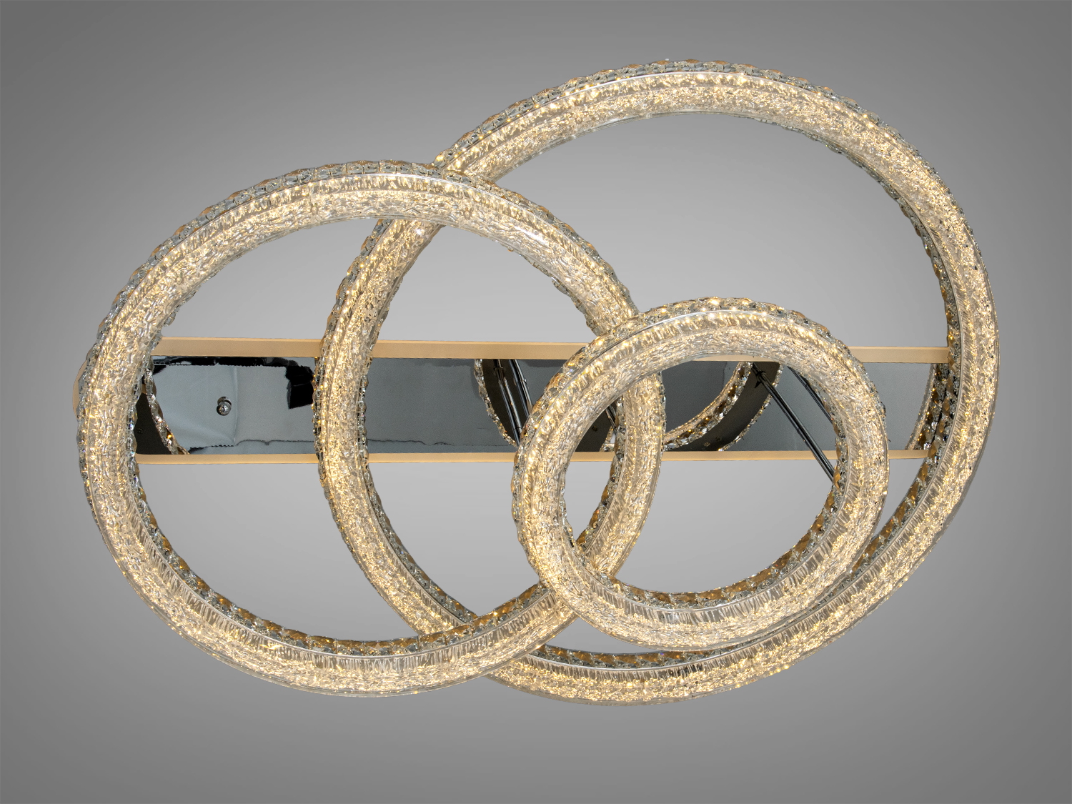 Стельовий світильник з трьома акриловими кільцями, що переплітаються, і дзеркальною основою для сучасного інтер′єру.