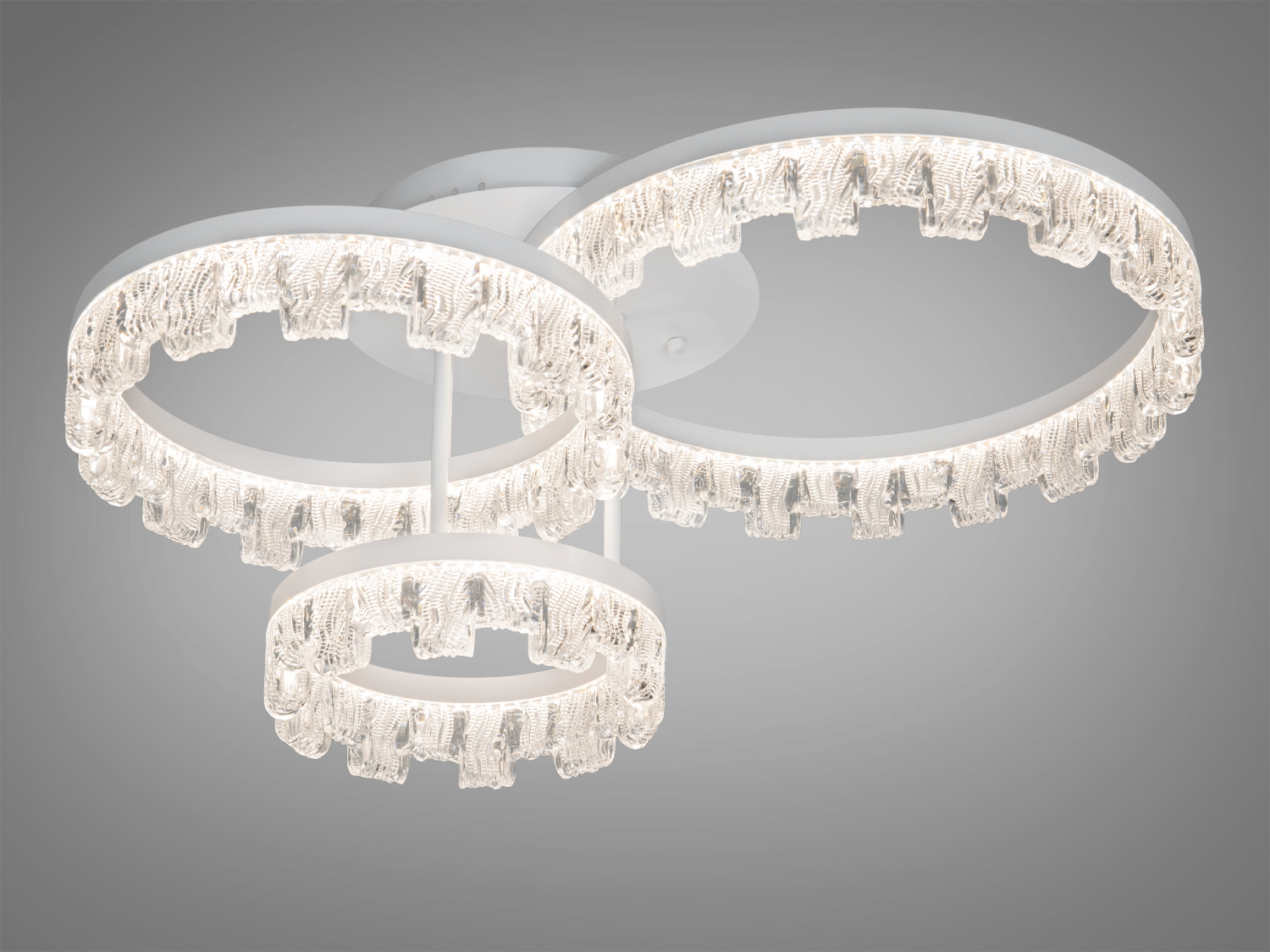 Стельовий світильник з трьома кільцями, що створюють м′яке біле світло. Виготовлений з прозорого матеріалу для рівномірного освітлення.