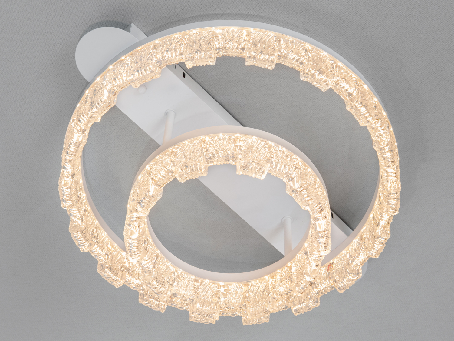 Стельовий світильник з теплим жовтим світлом, що підкреслює текстуру скла. Ідеальний для затишних житлових приміщень.