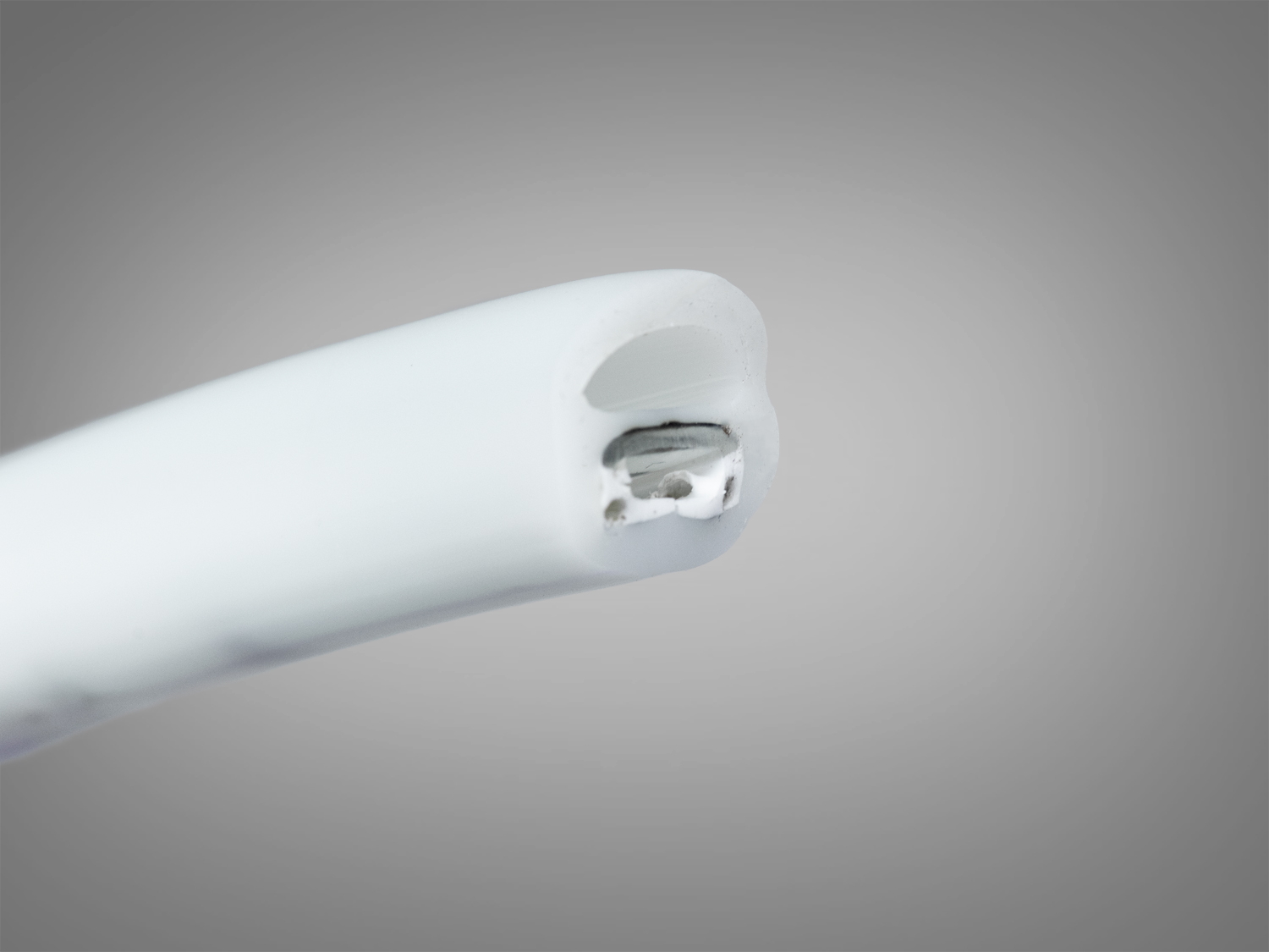 Крупний план кінця світлодіодного шнура з видимими контактами. Показує деталі конструкції та матеріалів.