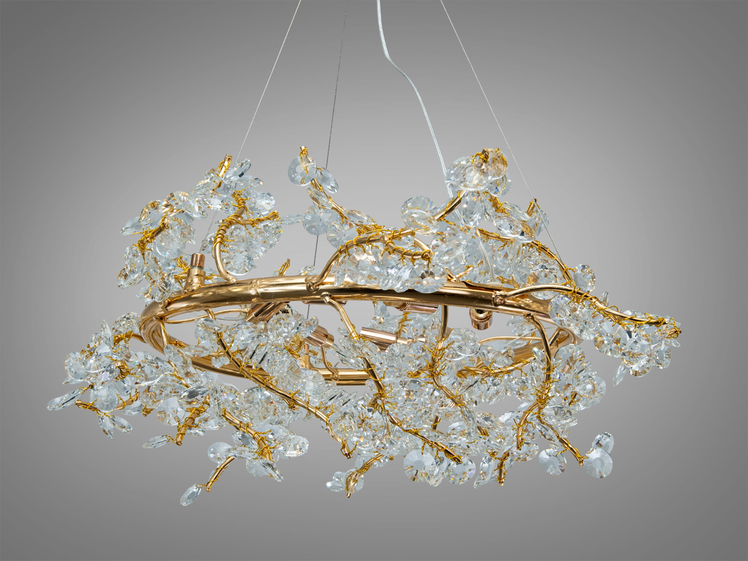 Люстра з кришталевими підвісками, золотистий метал, кругла форма, використовується для декоративного освітлення в сучасних інтер′єрах.