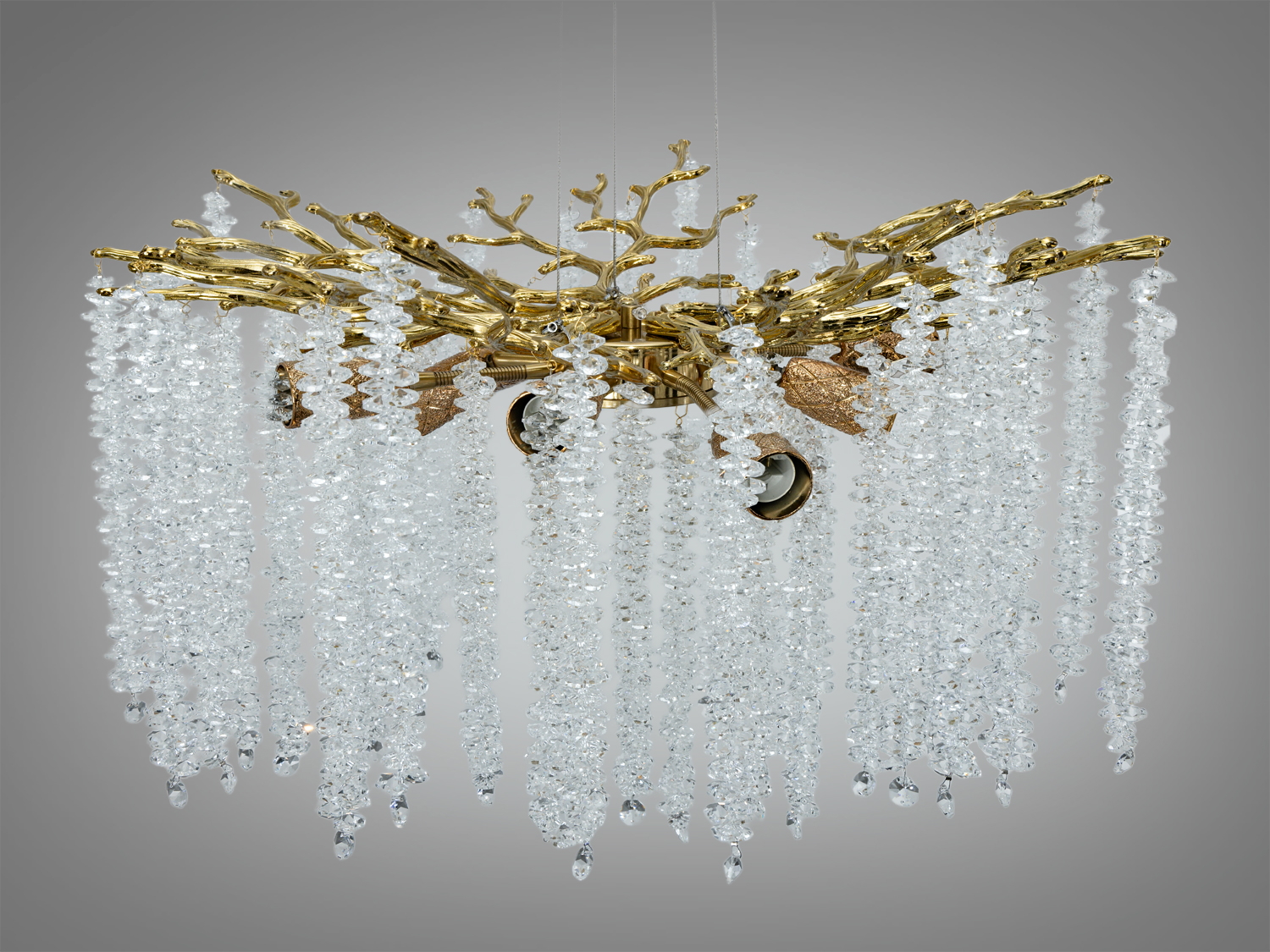Люстра з кришталевими підвісками, що звисають каскадом, на золотистій основі у формі гілок. Підходить для класичного інтер′єру.