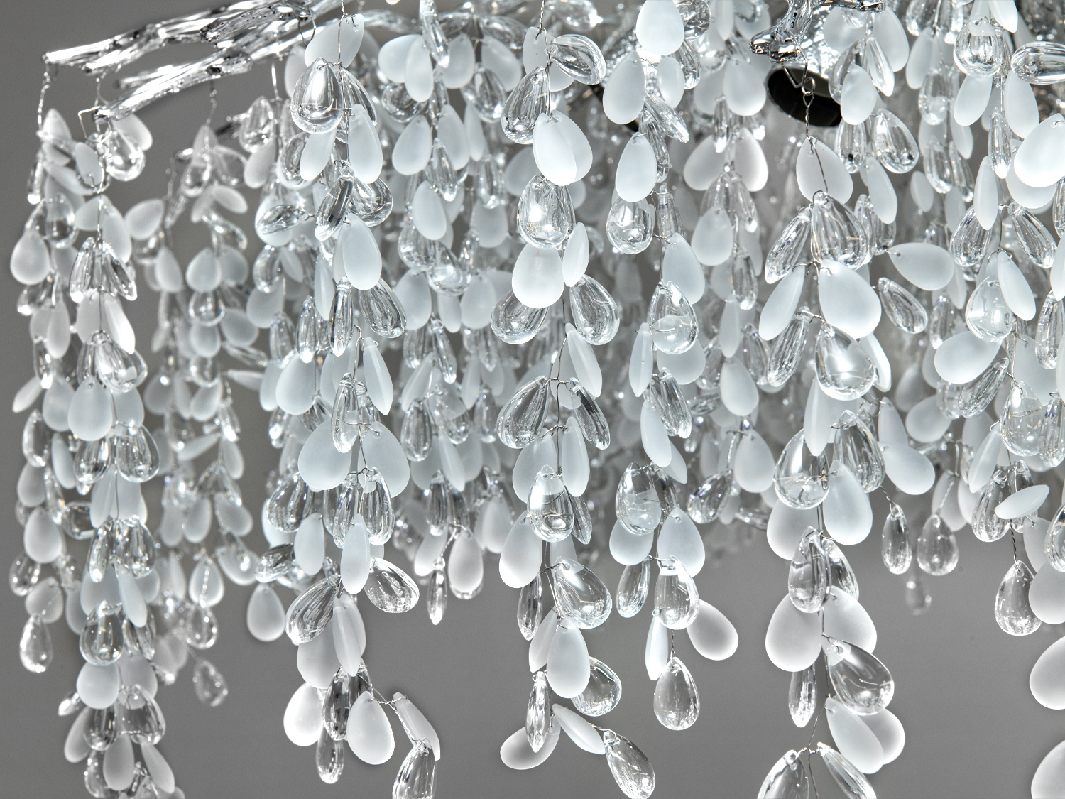 Детальний вигляд кришталевих підвісів люстри, прозорі та матові елементи, створюють візуальну динаміку, підходять для спальні.