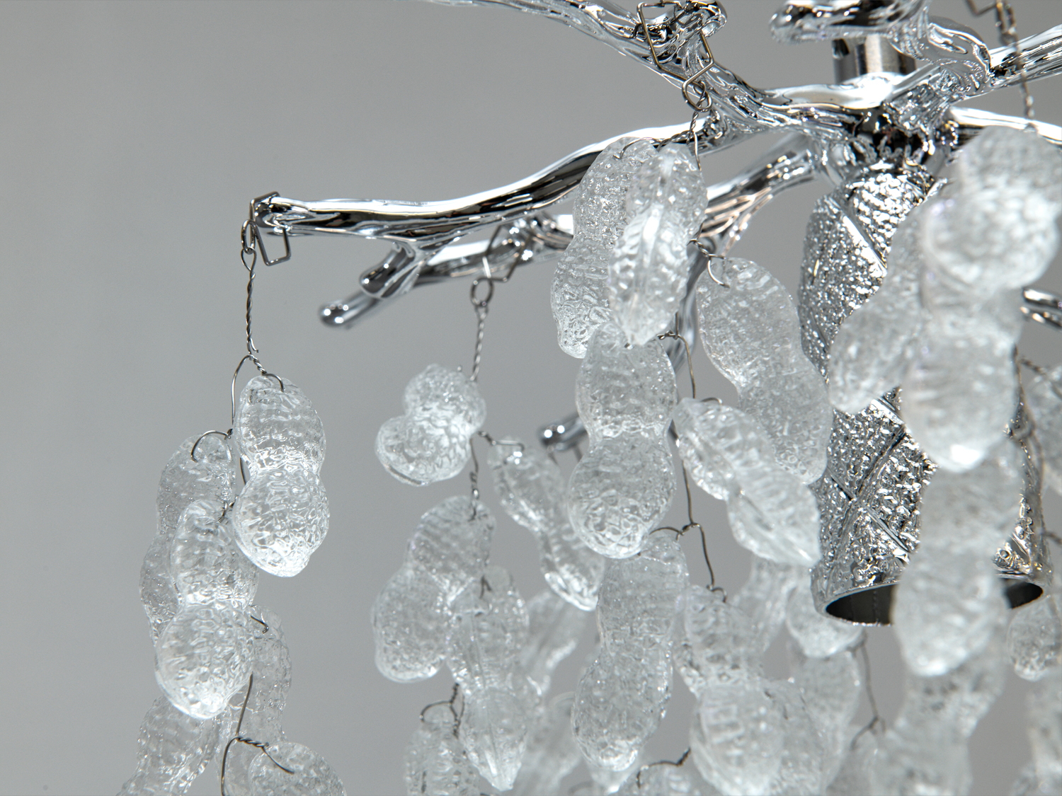 Деталь люстри з кришталевими підвісками на металевих гілках. Прозорі підвіски створюють ефект світлових відблисків.