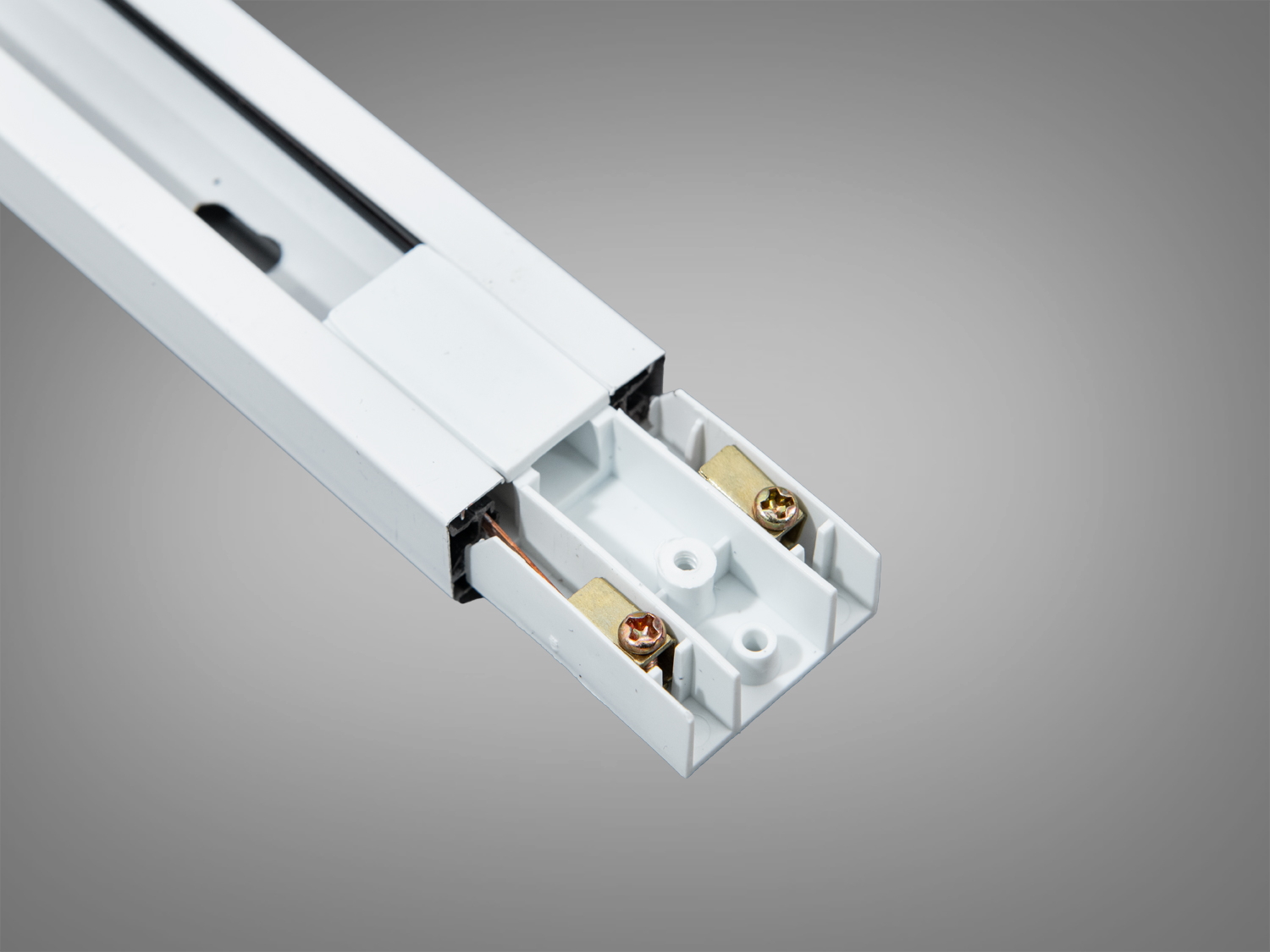 Кінець білого трекового профілю з двома гвинтовими контактами, що забезпечують надійне електричне з′єднання для освітлення.