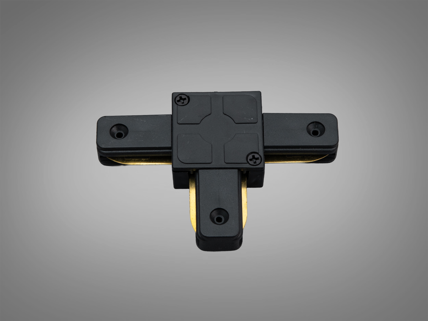 Чорний Т-подібний трековий конектор для з′єднання світильників у трековій системі освітлення, з отворами для монтажу на стіні або стелі.