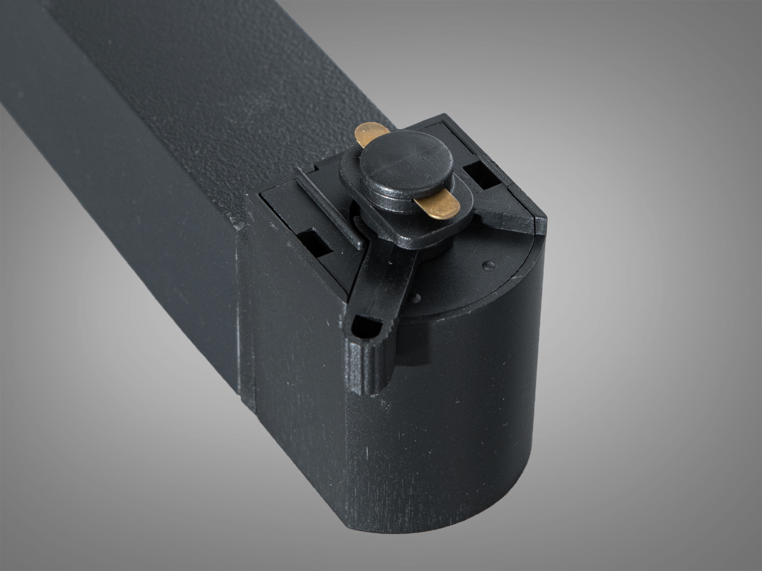 Деталь кріплення трекового світильника, чорний корпус з металевими контактами, забезпечує надійне з′єднання з трековою системою.