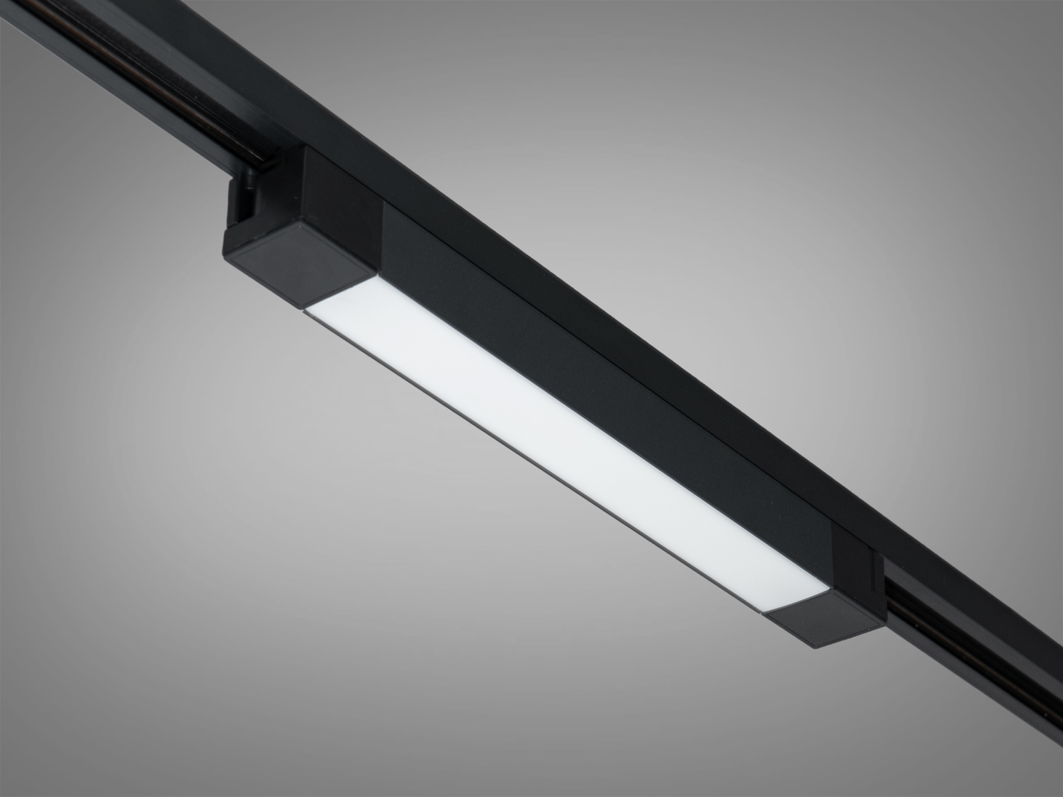 Компактний світильник з чорним корпусом, інтегрований у трекову систему, ідеальний для акцентного освітлення.