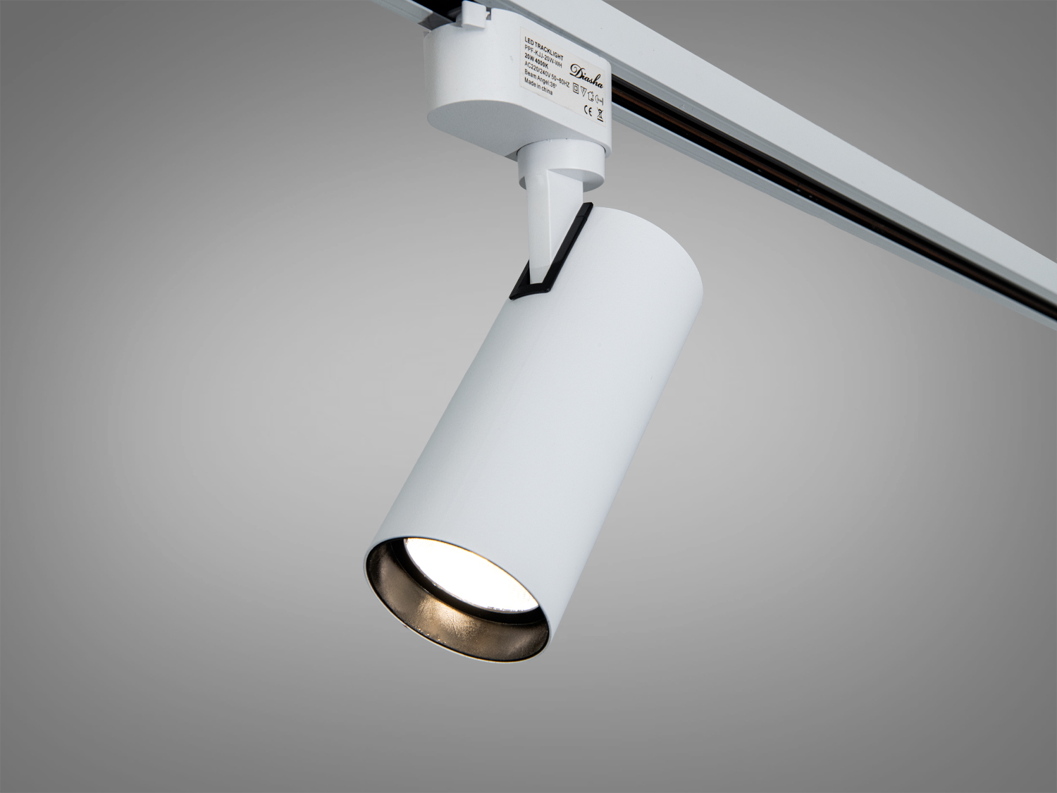 Білий трековий світильник циліндричної форми, ідеальний для монтажу на стелі, забезпечує рівномірне освітлення.