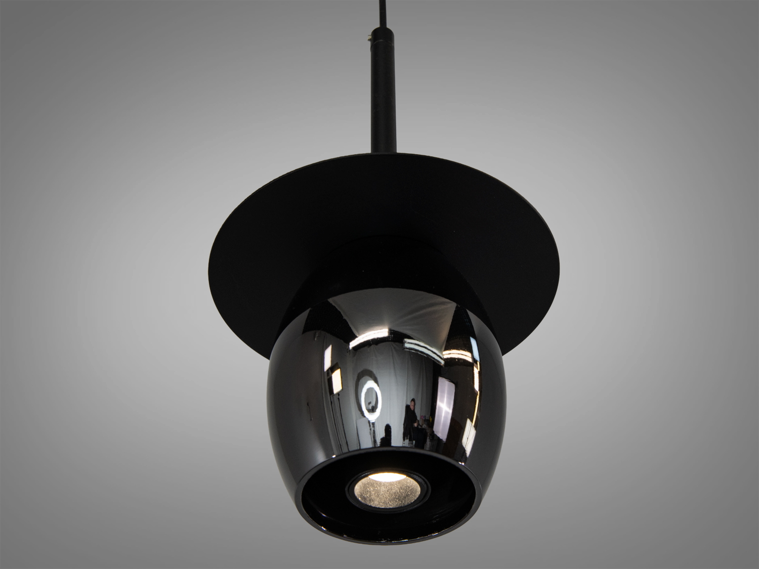 Чорний глянцевий плафон світильника з металевим обідком, що відбиває світло. Ідеальний для акцентного освітлення.