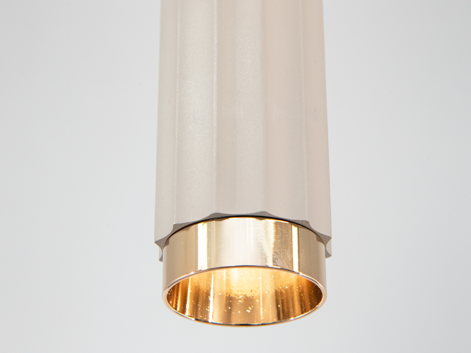 Деталь підвісного світильника з акцентом на золотистий металевий елемент. Підходить для акцентного освітлення в сучасних інтер′єрах.