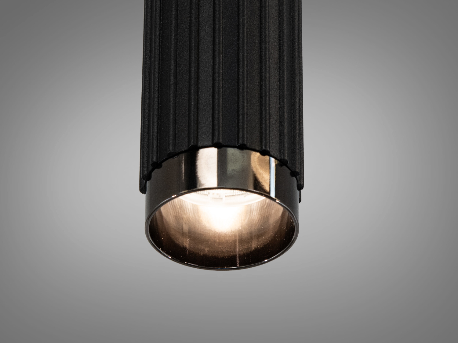 Близький план підвісного світильника з металевим обрамленням. Чорний корпус та срібляста окантовка додають елегантності.