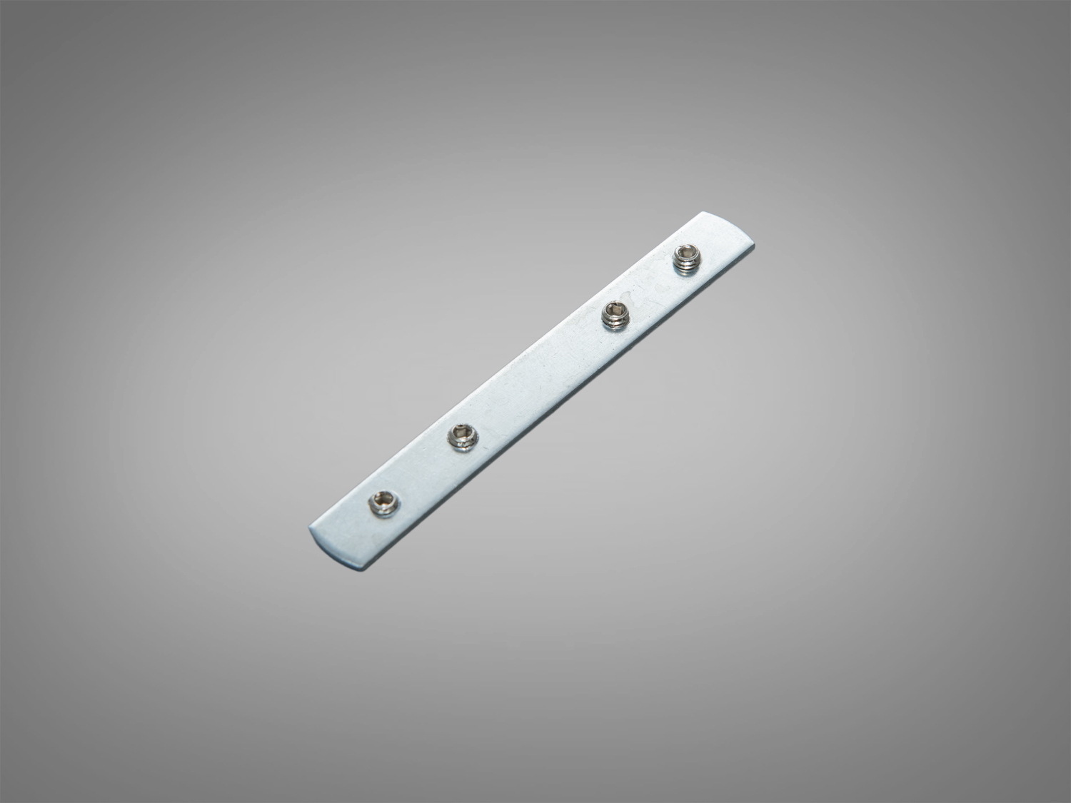 Металева монтажна пластина з чотирма отворами під гвинти, призначена для кріплення в магнітних трекових конструкціях. Має прямокутну форму та сріблястий колір.
