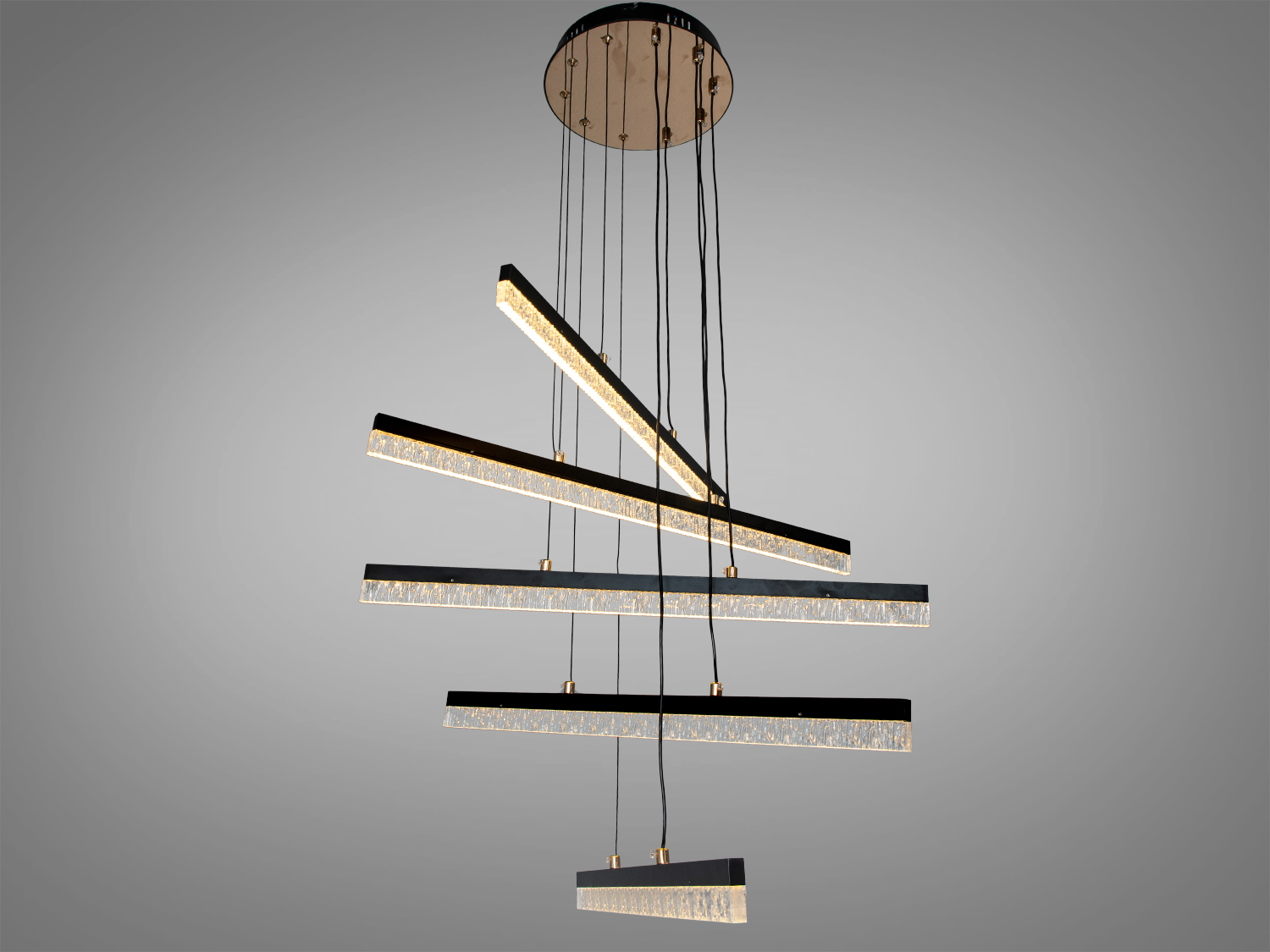 Підвісна лампа з теплим світлом, оснащена п′ятьма світлодіодними панелями, підвішена на чорних дротах для стильного освітлення приміщення.