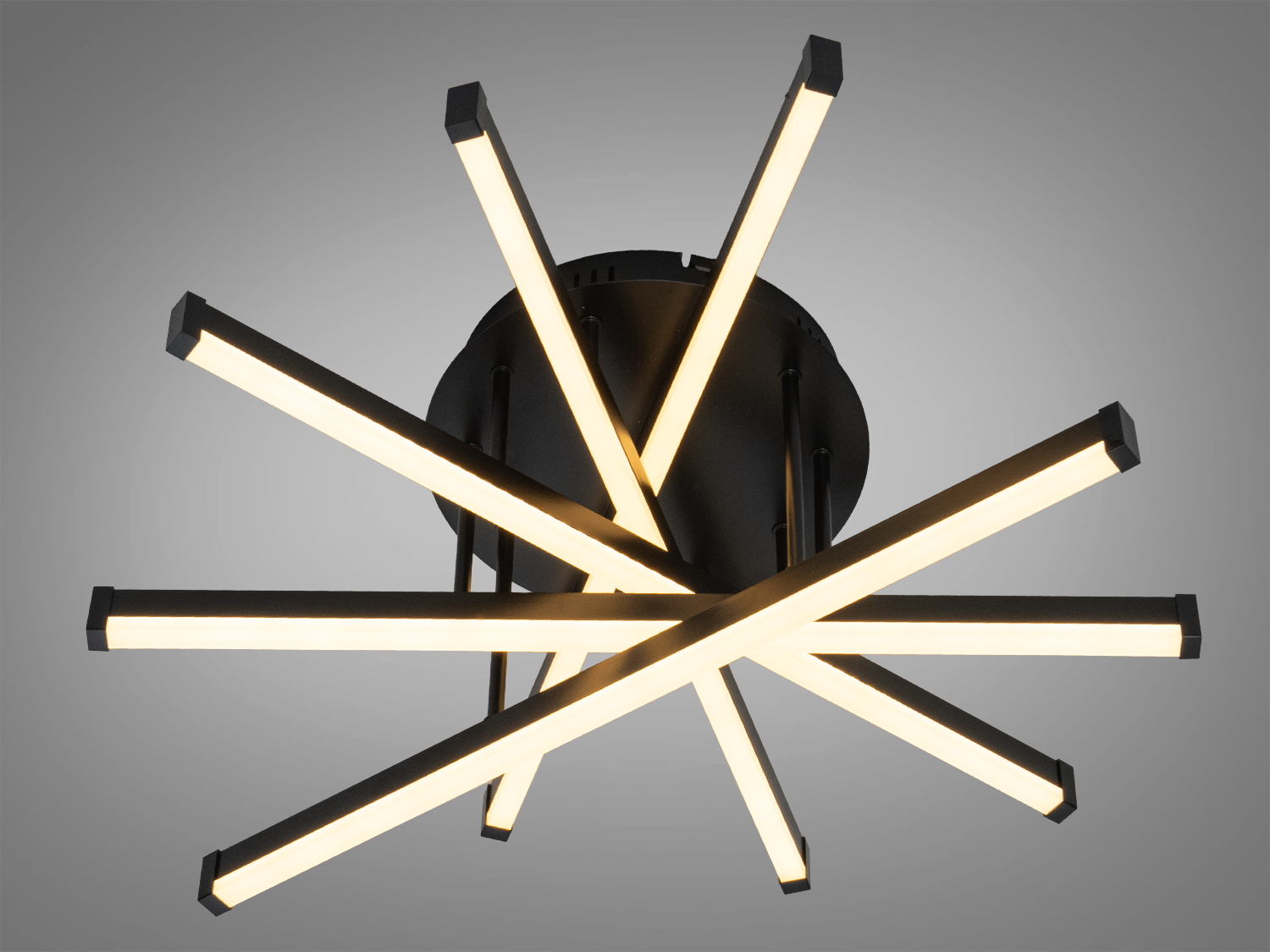 Стельовий світильник з чорними металевими планками, що утворюють зіркоподібну форму, випромінює тепле біле світло, підходить для сучасного інтер′єру.