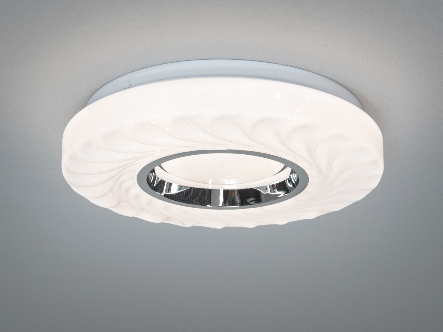 Круглий стельовий світильник з хвилястим візерунком і металевим обідком, призначений для монтажу в сучасних інтер′єрах.