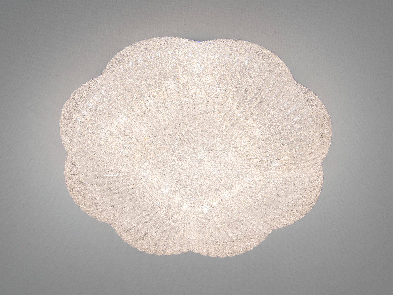 Світильник у формі квітки з текстурованого скла, що випромінює тепле світло. Ідеально підходить для монтажу на стелі в сучасних інтер′єрах.