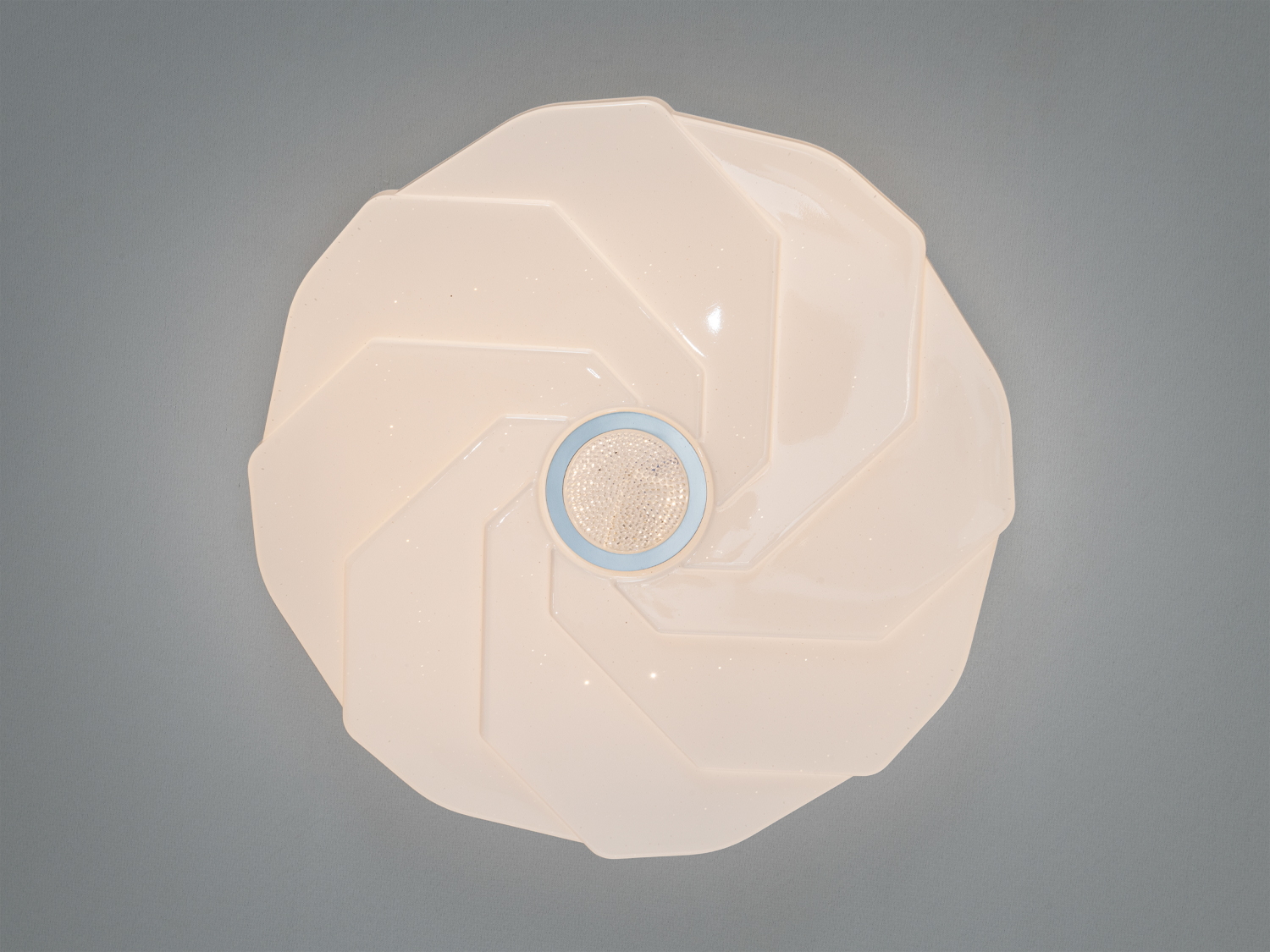 Кругла стельова лампа білого кольору з центральним світловим елементом. Підходить для офісів та комерційних приміщень.