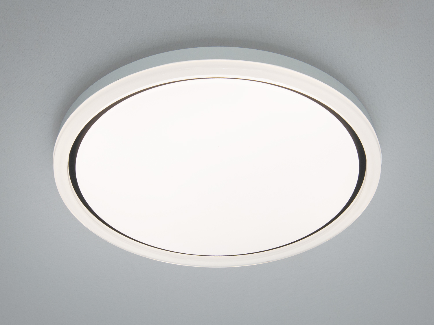 Кругла стельова лампа з білим корпусом, підходить для сучасного інтер′єру. Встановлюється на стелі, забезпечуючи рівномірне освітлення.