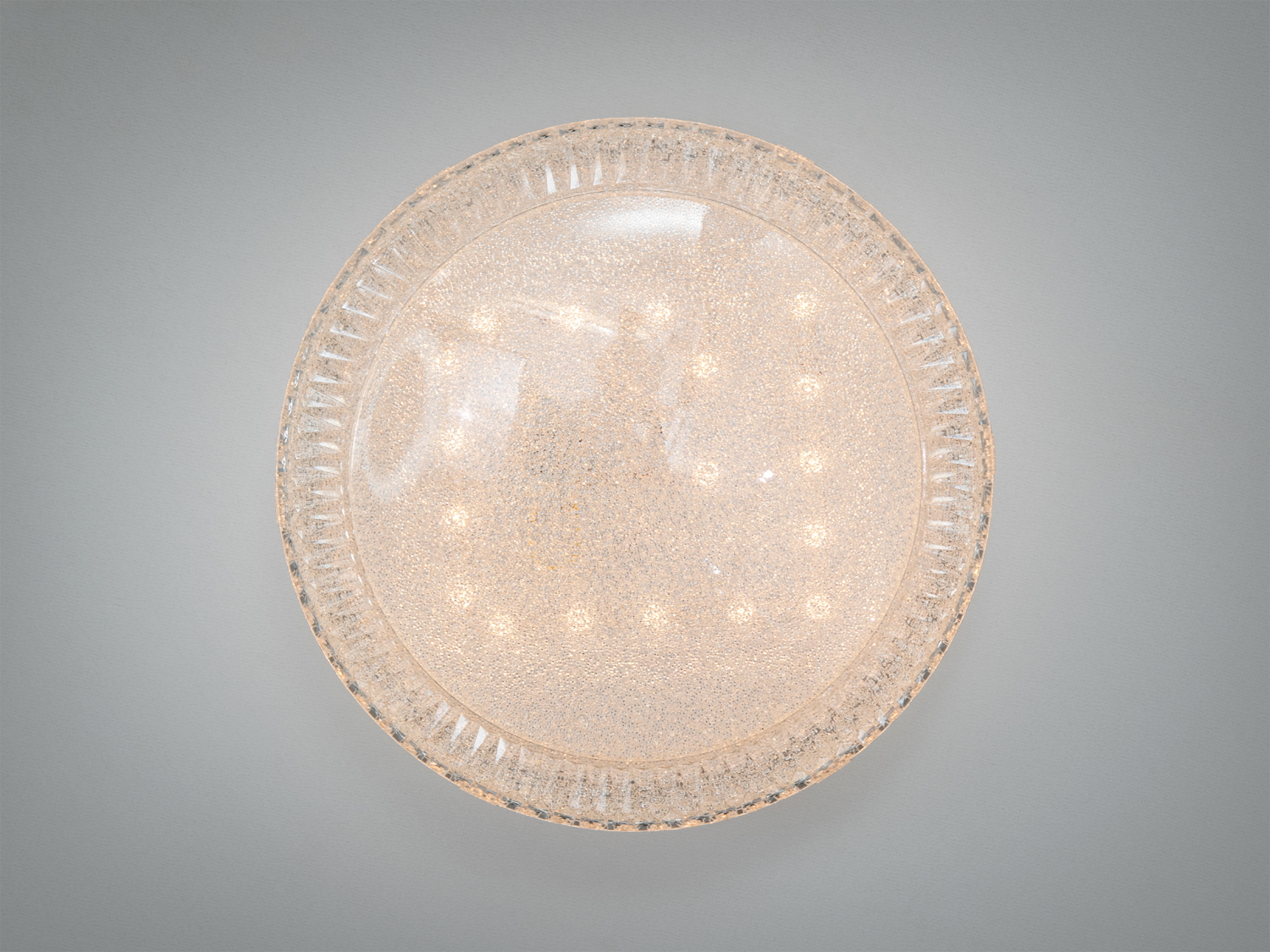 Вид знизу на круглу люстру з прозорого скла, що випромінює м’яке світло. Ідеально підходить для сучасних інтер′єрів.