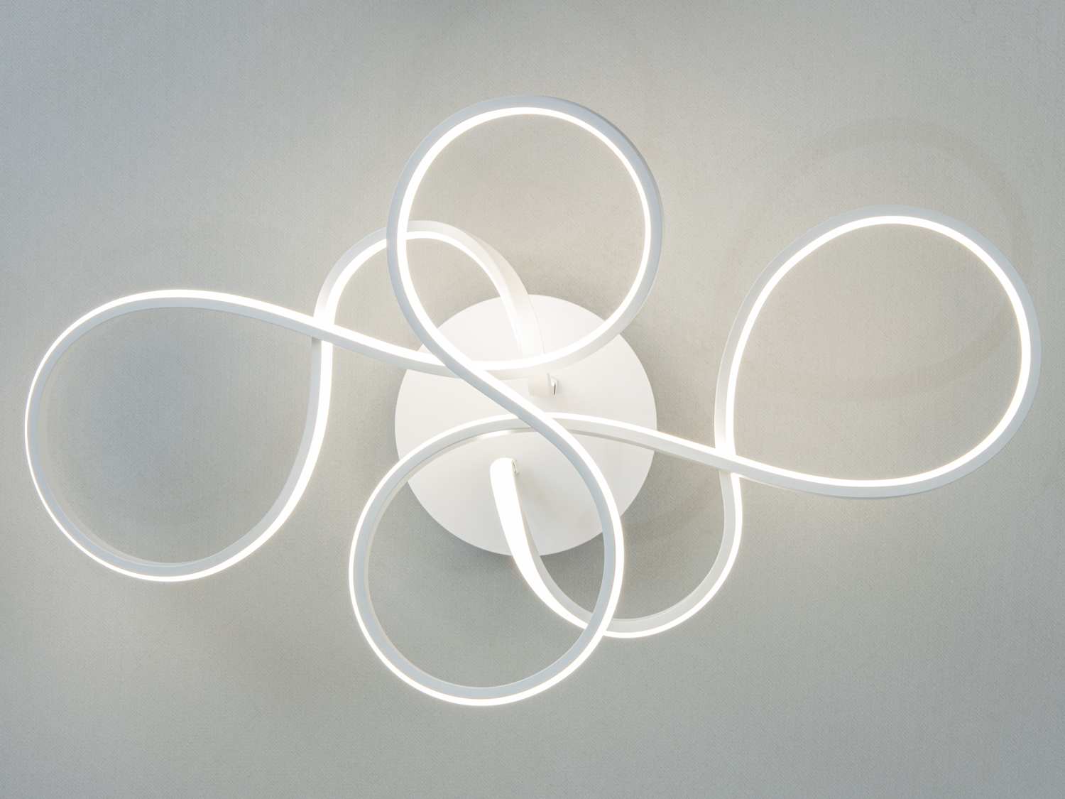 Стельовий світильник з переплетеними LED-смугами, білий колір, ідеальний для мінімалістичних просторів, забезпечує рівномірне світло.